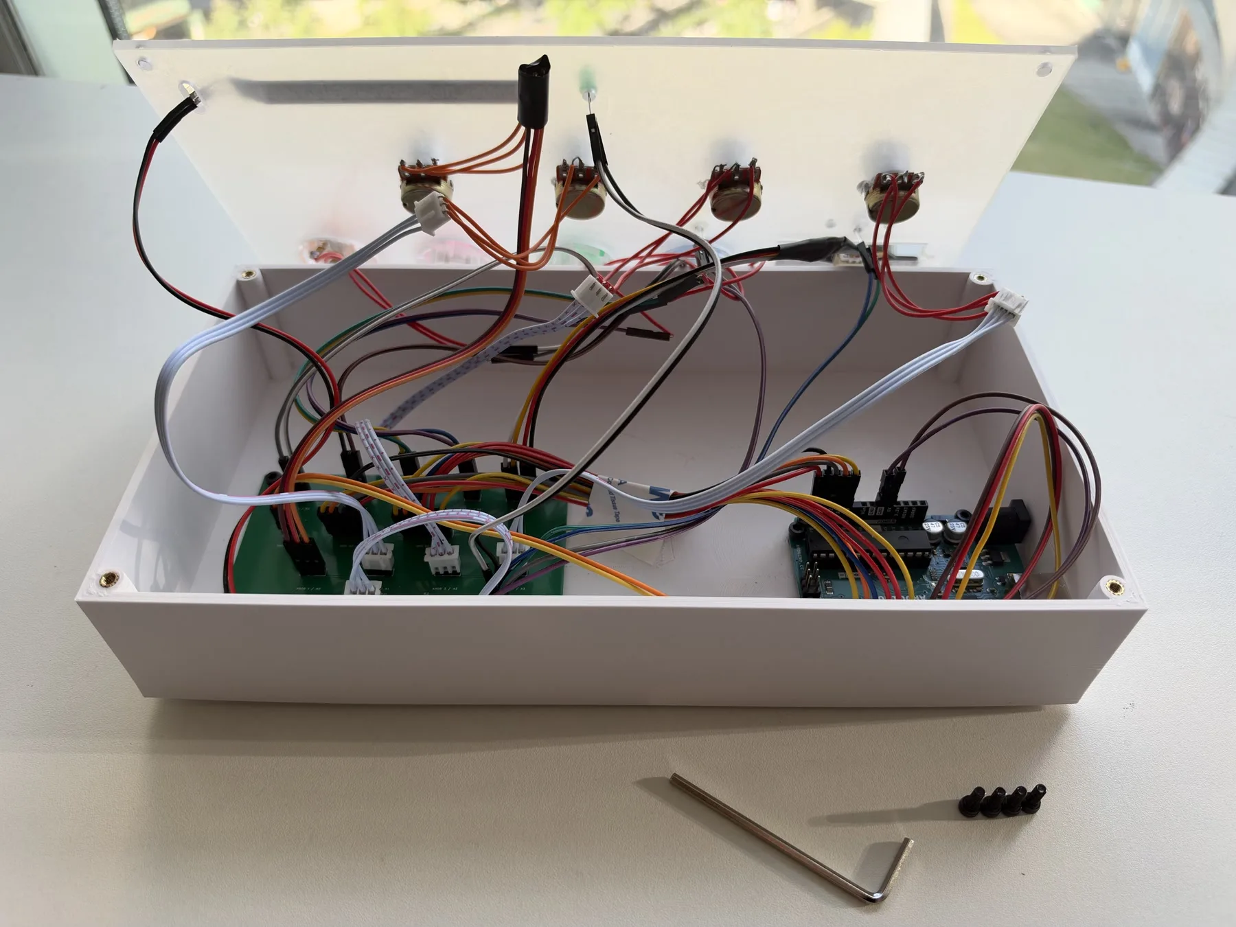 Open white enclosure showing potentiometers in the panel, the carrier board, the Arduino and colour-coded wiring.